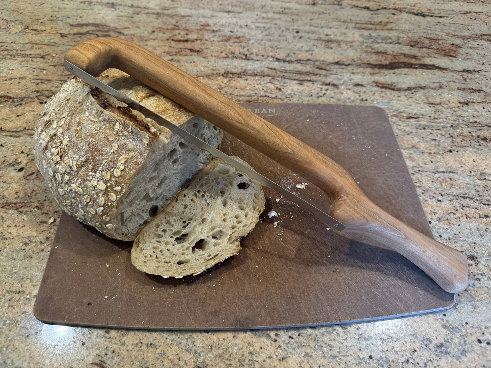 Handmade bread knife with a sculpted hardwood handle by Novelty Woodworks